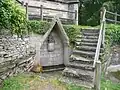 Chapelle Notre-Dame de Lambader : la fontaine du mur sud de la chapelle et sa pietà.