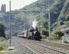 Train touristique à voie étroite empruntant la ligne SNCF à la sortie de Tournon.