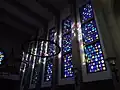 Image prise de l'intérieur de la cathédrale, centrée sur des vitraux colorés.