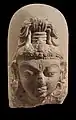 Linga à visage divin : le troisième œil sur le front symbolise l'omniscience de Shiva. VIIIe – IXe siècle. Calcaire, H. 25 cm. Inde du Nord
