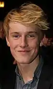 photographie en couleurs du visage d'un jeune homme blond.