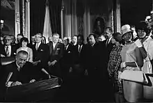Photographie de Rosa Parks, Martin Luther King et d'autres membres du mouvement pour les droits civiques lors de la signature du Voting Rights Act de 1965 par Lyndon B. Johnson dans la rotonde du Capitole.