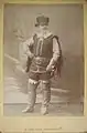 photo recto : Gally en tenue de scène soldat, devant des décors