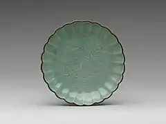 Assiette à bord festonné et à décor incisé sous couverte céladon. Porcelaine d'Arita ; type Imari, mi-XVIIe&nbsp;siècle (Metropolitan Museum of Art).