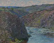 Une vallée encaissée où coule une rivière et où pousse de la végétation.