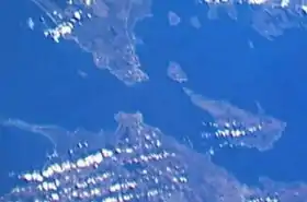 Image satellite du détroit de Mackinac, qui sépare la péninsule supérieure du Michigan (en haut) de la péninsule inférieure. À droite, les deux îles habitées : l'île Mackinac et la plus grande île Bois Blanc.