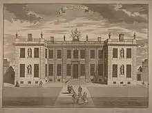 Gravure en noir et blanc d'un bâtiment en U, à un étage. En premier plan, une allée y mène.