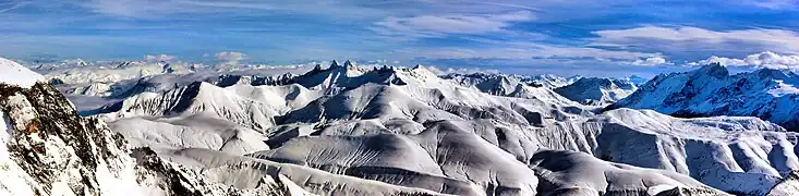 Vue depuis le massif des Grandes Rousses en direction de l'est avec les aiguilles d'Arves et le Goléon au centre et la Meije à droite.
