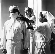 Pose d'un masque de protection bouche-nez à Calcutta (1944).