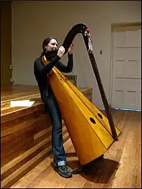 Jeune femme accordant une harpe andine.
