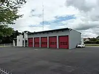 Photographie en couleurs d'un grand garage fermé par cinq hautes portes peintes en rouge.