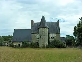 Photographie en couleurs d'un manoir dont la façade est flanquée en son centre d'une tour.