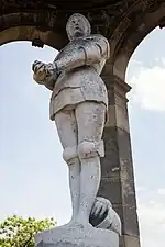 Statue de Jeanne d'ArcStatue de marbre blanc, recouverte lors de son inauguration de feuilles d'or, l'original de la statue est désormais, débarrassé de sa gangue d'or, à l'abri dans la basilique Notre-Dame et remplacée sur le monument par une copie recouverte de feuilles d'or, depuis les années 1990.