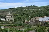 Photographie de collines dans lesquelles s'insère un bâtiment monastique.