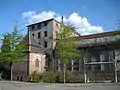 La porcherie en 2006 (à gauche) ; l'usine en arrière plan (détruite en 2009).