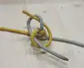 Nœud de cul de porc à 2 brins utilisé pour faire un bracelet Snake bicolore