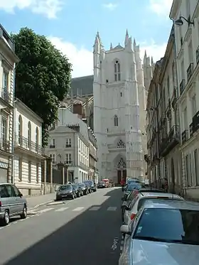 Photo de la rue du Roi-Albert, à Nantes ; elle est longée de bâtiments du XIXe siècle rectilignes et blancs, on voit au fond se dresser la cathédrale de Nantes