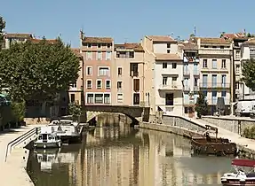 Vue de l'unique arche visible aujourd'hui du pont, et des habitations s'élevant dessus.