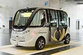Navya aux couleurs de CarPostal France au salon CeBIT, testée à Sion pour CarPostal Suisse