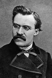 Buste d'homme. Sur fond neutre, le visage et le regard sont tournés vers la gauche, donnant du mouvement au portrait. Le personnage moustachu porte de fines lunettes rondes, un nœud papillon fin et un manteau noir fermé