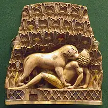 Plaque montrant un lion mordant le cou d'un homme sur le dos, une des ivoires de Nimrud&nbsp;(en), période Néo-Assyrienne, IXe&nbsp;– VIIe&nbsp;siècle&nbsp;av. J.-C.