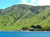 Photographie d'une île dont les pentes raides déboisées plongent dans la mer.