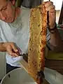 Désoperculation d'un cadre avant l'extraction du miel (en)