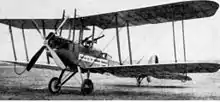 Photo noir et blanc d'un avion biplan au sol.