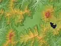 Carte montrant le relief d'une zone géographique comprenant une plaine (en vert) entourée de montagnes (jaune - orange), et une étendue d'eau à droite (noire).