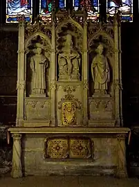Autel néogothique avec trois statues Saint Vincent, Trinité, Saint Germain, formant retable (XIXe siècle).