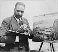 Le peintre Palmer Hayden travaillant sur une peinture de paysage, n. d.