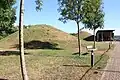 Vue rapprochée de tumulus en terre engazonnés.