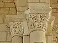 Des chapiteaux sculptés au sommet de deux colonnes.