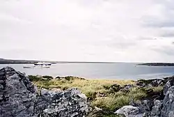 Un bateau de croisière et un chalutier pour la pêche aux calmars dans Port William, vue partir du site proposé pour la construction d'un nouveau port en eau profonde.