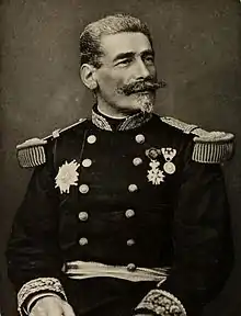 Photo en noir et blanc d'un homme, debout, en tenue de général et portant des décorations.