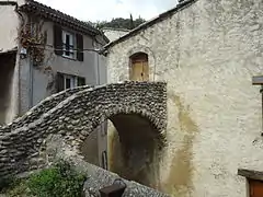 Pounti passant au-dessus d’une ruelle.