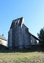 Le clocher-mur « aveugle » soutenu par deux imposants contreforts.