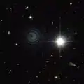 Image de IRAS 23166+1655 prise par le télescope spatial Hubble dans le proche-infrarouge. L'objet brillant à droite est une étoile beaucoup plus proche de la Terre.