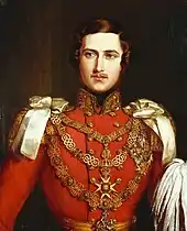Portrait du buste d'un homme en tenue d'apparat rouge. Il porte la moustache et trois colliers d'or.