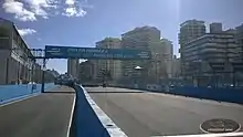 Photographie d'une ligne de départ/arrivée d'un circuit, sous un ciel bleu.