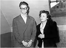 Photographie en noir et blanc d'un homme menotté et d'une femme à ses côtés.