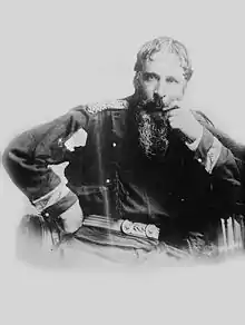 photographie noir et blanc : un homme barbu en uniforme, assis
