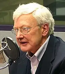 Un homme aux cheveux blancs avec des lunettes.
