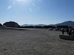 Des camions attendent à la frontière chinoise. La route est asphaltée.