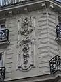 No&nbsp;50, bas-relief à tête de lion dégorgeant un faisceau de fruits et de légumes.
