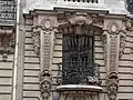 No&nbsp;97 : détails d’une embrasure de fenêtre avec balcon galbé en fer forgé.