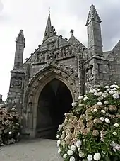 Photographie d'un porche d'église en granite, sculpté en bas-relief