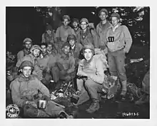 Des survivants du Lost Battalion (1er bataillon, 141e d’infanterie, 36e division d’infanterie américaine) se réchauffer autour d’un feu en attendant leur évacuation vers l’arrière le 31 octobre 1944.