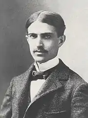 noir et blanc, homme jeune, chevelure abondante, raie au milieu, petite moustache