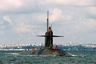 Un sous-marin émergé sur la mer avec des matelots sur son pont se dirigeant vers le photographe